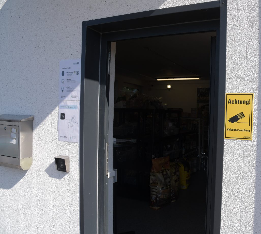 Eingangstür des Tierfuttershops mit Scanner an der Wand und Anleitung zum Einchecken