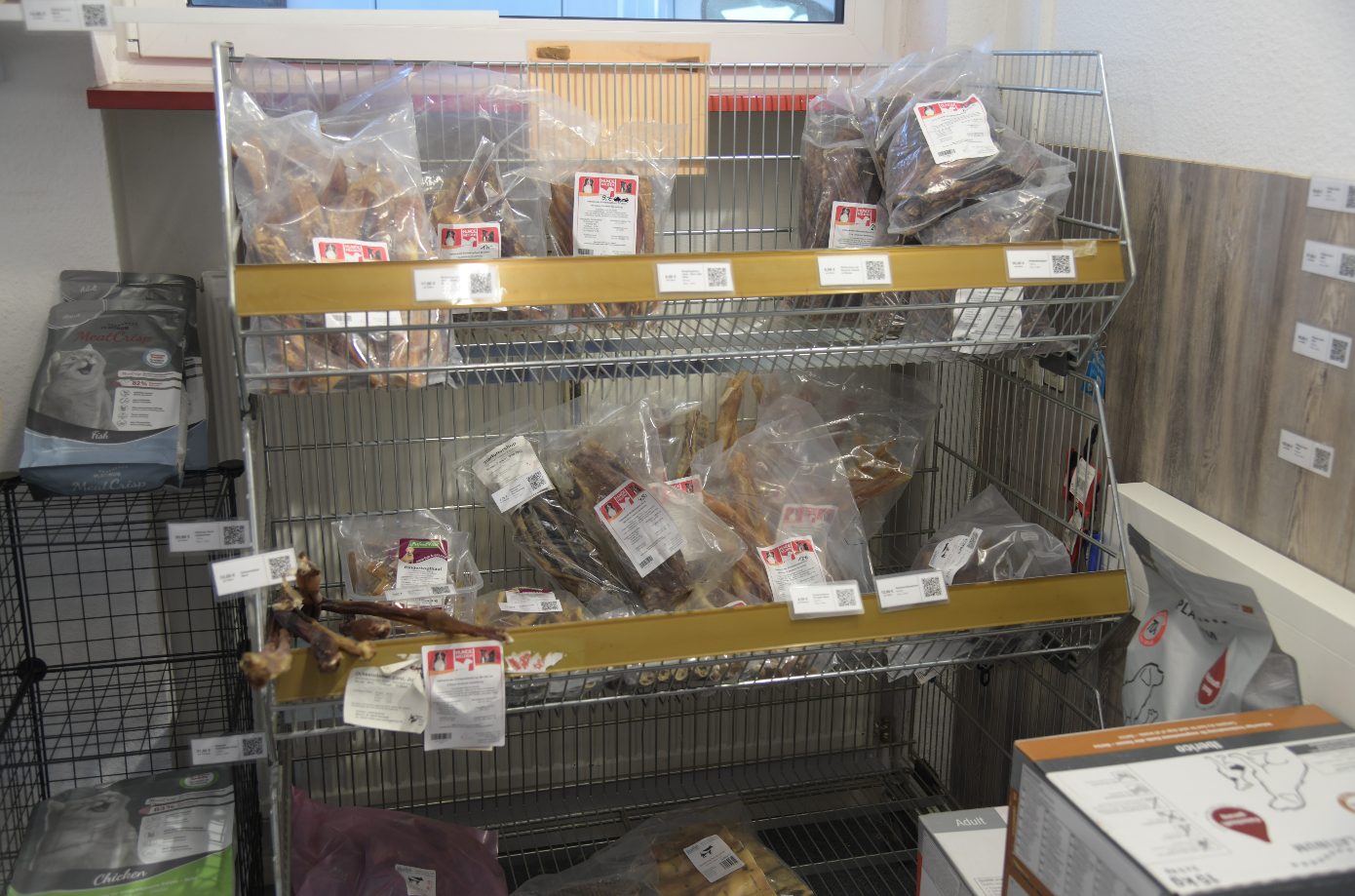 Gitterregal mit verpackten Kauartikeln für Hunde